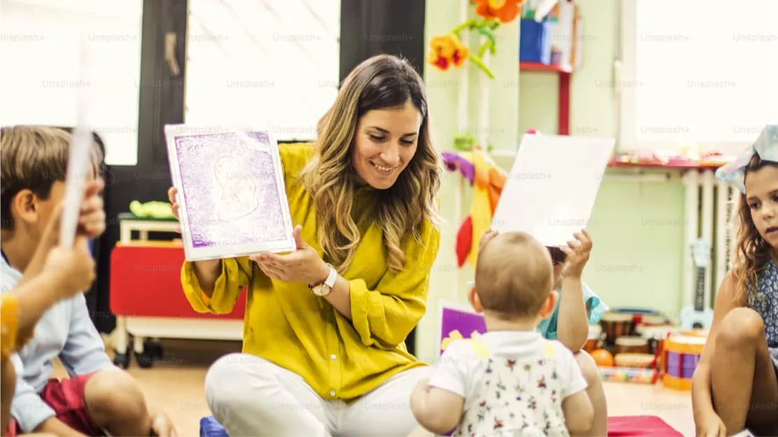 A woman shares a book with children in a cheerful classroom, fostering a love for reading and learning together